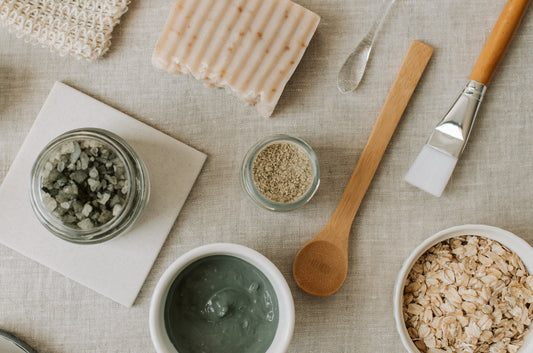different raw ingredients used in skincare separated in bowls and utensils on neutral background