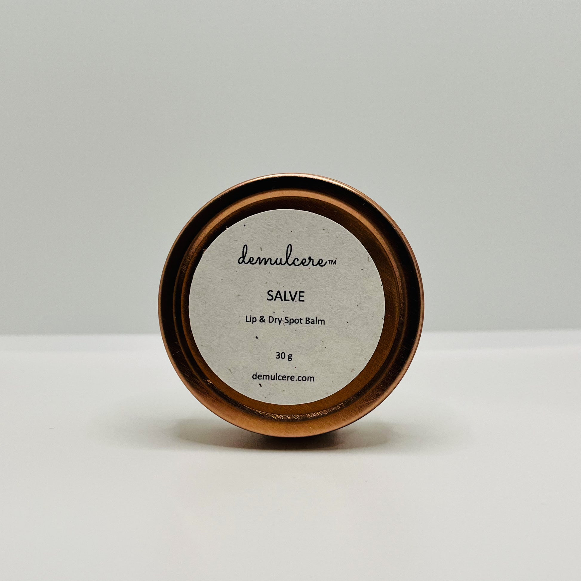 30g balm in round rose gold tin on white background